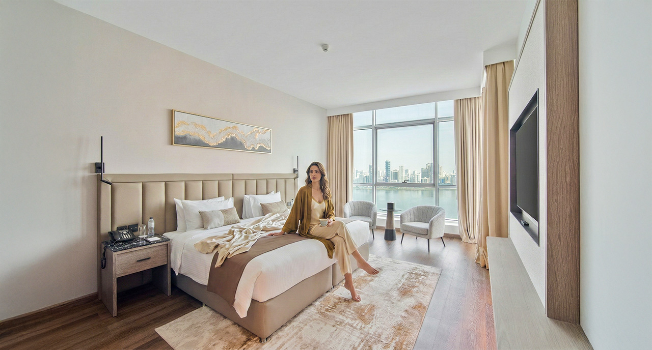 Suite room at Copthorne Hotel Sharjah with lagoon view, spacious bedroom and modern seating area